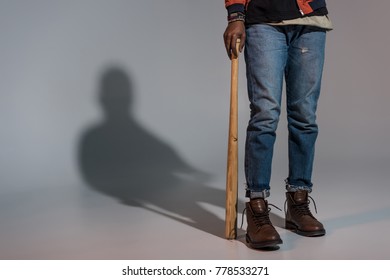 Partial view of guy leaning on baseball bat