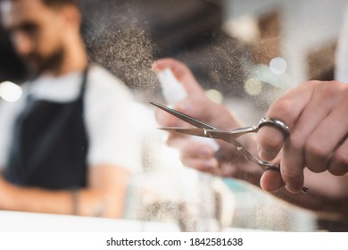 partial view of hairdresser sanitizing scissors with antiseptic on blurred background - Powered by Shutterstock