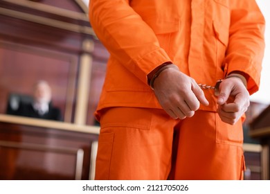 Partial View Of Handcuffed Man In Jail Uniform In Courtroom