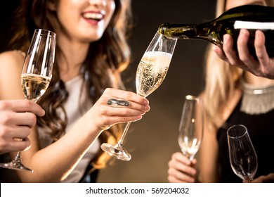 Partial view of happy young friends drinking champagne 