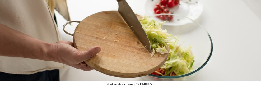 Partial View Of Man With Chopping Board Adding Cut Lettuce Into Bowl While Preparing Vegetable Salad, Banner