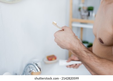 Partial View Of Man Holding Toothbrush With Toothpaste In Bathroom