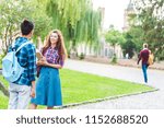 partial view of multiracial students having conversation in park