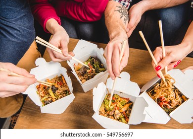 Partial View Of People Eating Noodles With Chopsticks 