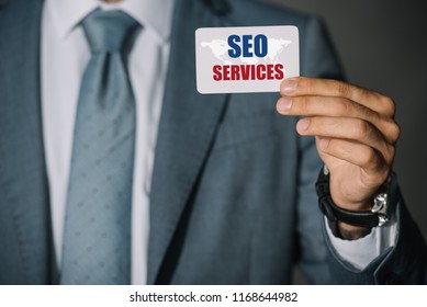 partial view of professional developer showing card with with SEO services and world map