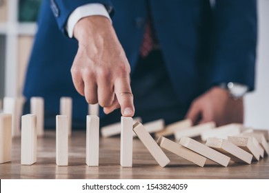 partial view of risk manager blocking of falling wooden blocks  - Shutterstock ID 1543824059