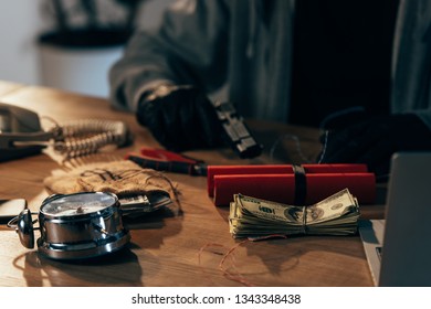 Partial View Of Terrorist Sitting At Table With Money And Weapon