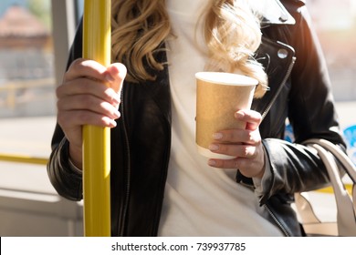 Partial View Of Woman With Coffee To Go Holding Bus Handle