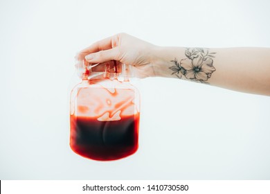 Partial View Of Woman With Tattoo Holding Blood Bag Isolated On White