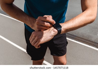 Partial View Of Young Sportsman Using Smartwatch On Running Track