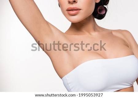 partial view of young woman in white top with smooth armpit isolated on white