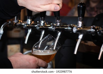 Partially Blurred Hand, Pouring Beer From Silvery Bar Tap In A Pub