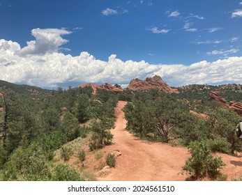 A Partially Cloudy Blue Sky With A Hiking Trail Running Straight Up A Rocky Hill At The Garden Of The Gods In Manitou Springs, Colorado.