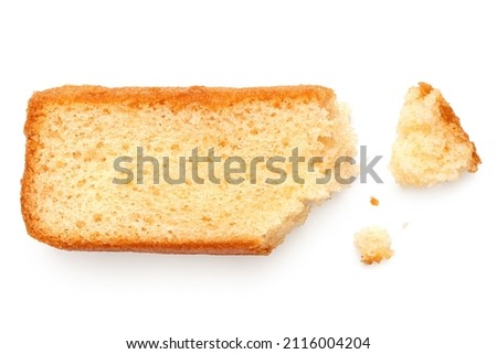 Partially eaten slice of plain sponge cake lying flat isolated on white. With crumbs. Top view.