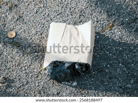 A partially melted and burned firework shell lying on the pavement in Strasbourg's Cite Rotterdam area, reflecting the aftermath of New Year 2024-2025 festivities.