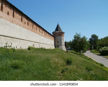 partially restored fortified wall of red brick, corner tower with a wooden roof - Shutterstock ID 1141890854