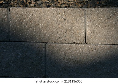 Partially shaded cinderblock retaining wall in evening light. 
