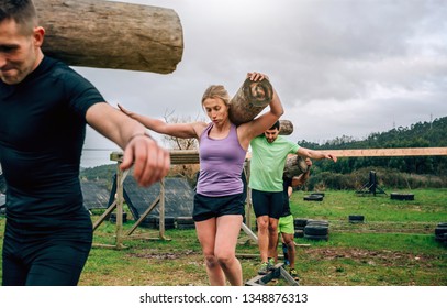 Participants in an obstacle course carrying trunks outdoors - Powered by Shutterstock