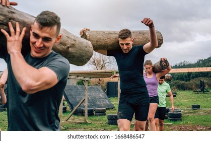 Participants in an obstacle course carrying trunks outdoors - Powered by Shutterstock