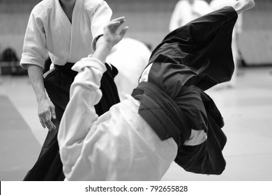 The participants of the training in special clothes of aikido hakama work out the methods of single combat
