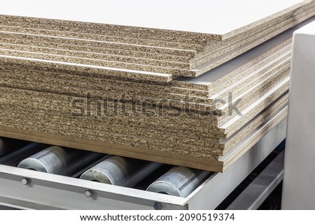 particle boards are stacked on a wood-cutting machine at a furniture factory Stock foto © 