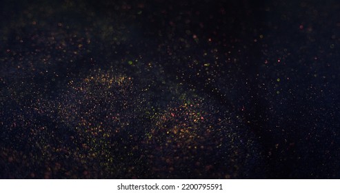 Particles background. Bokeh glitter texture. Blur shimmering sparks. Defocused purple bronze golden color grain on dark blue night abstract wallpaper.