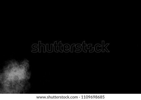 particles of charcoal on black background,abstract powder splatted background.Freeze motion of White powder exploding or throwing White powder.