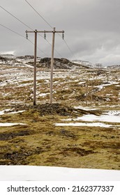 Partly snow-covered mountain landscape near Olafsvik in Iceland with wooden electricity pylons and power lines
