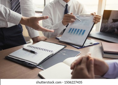 Partner colleagues are talking about the results in the document on hand and together analyze the work data about the company's financial statements.