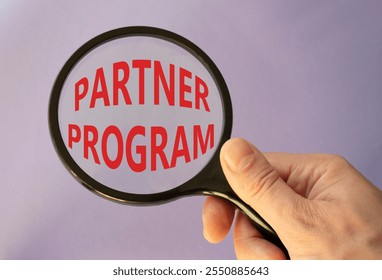 Partner Program symbol. Concept words Partner Program on magnifying glass. Businessman hand. Beautiful purple background. Business and Partner Program concept. Copy space.