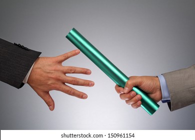Partnership or teamwork concept two businessmen handing over a baton