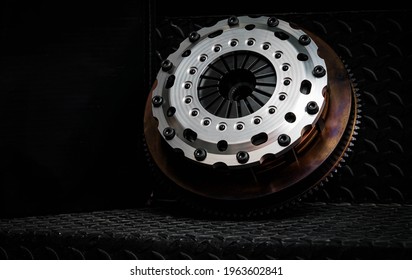 Parts of the car on a steel plate and a black background, silver clutch.