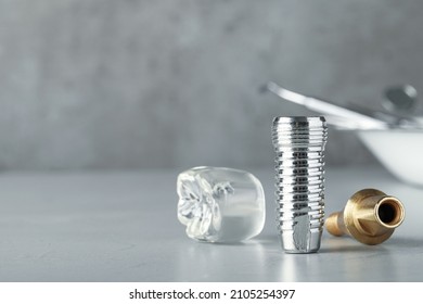 Parts Of Dental Implant On Grey Table. Space For Text