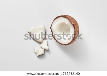 Parts of fresh natural organic tropical fruits coconut on a light grey background with copy space. Vegetarian concept.