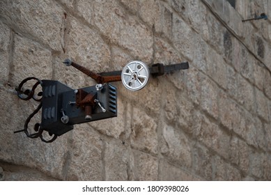 Parts Of An Old Movie Projector Sign Sit On A Beige Stone Wall In A Small Mediterranean Town Steeped In History. Wallpaper, Background, Postcard.