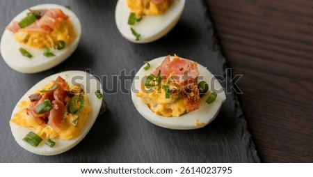  party appetizer featuring deviled eggs topped with crispy bacon and chopped green onions