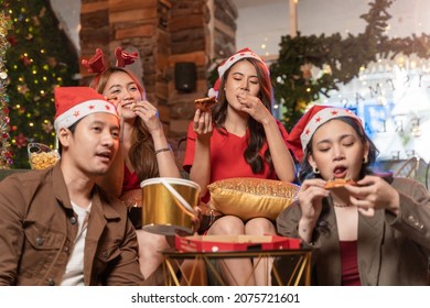 Party Of Beautiful Asian Friend Female And Male Watching Tv. People Eating And Having Fun When Watching Movie. Happiness Friends Christmas Eve Celebration Dinner Party.