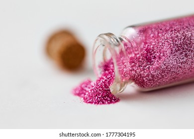 party, decoration and holidays concept - close up of pink glitters poured from small glass bottle and cork over white background - Powered by Shutterstock