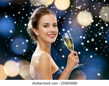 party, drinks, holidays, christmas and people concept - smiling woman in evening dress with glass of sparkling wine over night lights and snow background - Powered by Shutterstock