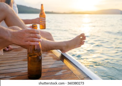 Party With Friends. Close Up Male Hand Holding Bottle Of Beer On The Yacht Sailing The Sea.