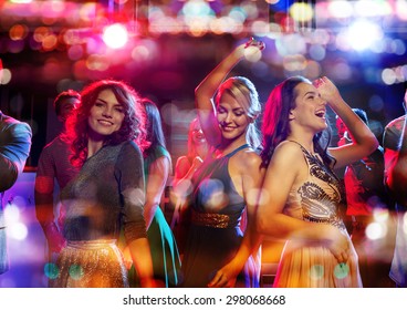 party, holidays, celebration, nightlife and people concept - happy friends dancing in club with holidays lights
