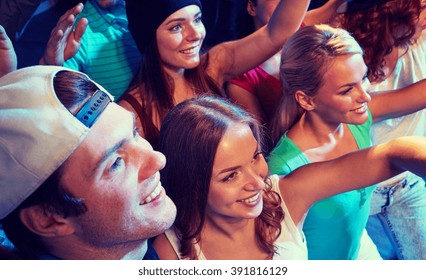party, holidays, celebration, nightlife and people concept - smiling friends waving hands at concert in club - Shutterstock ID 391816129