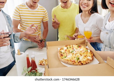 Party Host Opening Box Of Delicious Hot Pizza In Front Of Her Excited Friends