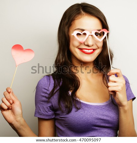 Party image. Playful young woman holding a party heart.