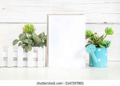 Party Invitation Mockup On A Light Background With Flowers. Vertical White Card 5x7 On The Table Against A Light Wall.