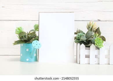 Party Invitation Mockup On A Light Background With Flowers. Vertical White Card 5x7 On The Table Against A Light Wall.