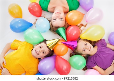 Party Kids And Their Mother Laying Among Colorful Balloons