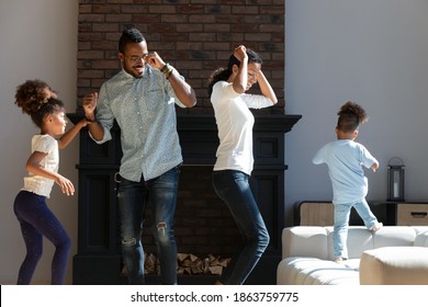 Party In Living Room. Happy African American Family Of Four, Young Spouses And Two Kids Preteen Daughter And Preschool Son Laughing Dancing At Home Listening Good Music Spending Active Weekend Indoors