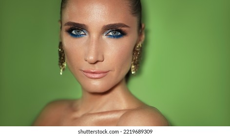 Party Make Up. Fashion Beauty Portrait Of A Mature Woman With Smokey Eyes Make Up Wearing Golded Jewerlys Posing Against Green Background.