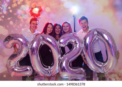 Party, people and new year holidays concept - women and men celebrating new years eve 2020
